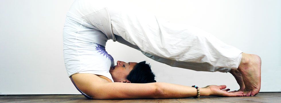Valérie Palmieri, professeure de yoga, en posture de la charrue (Halasana)